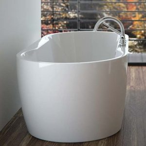 Bain autoportant blanc aux angles arrondis avec robinet sur le rebord du bain