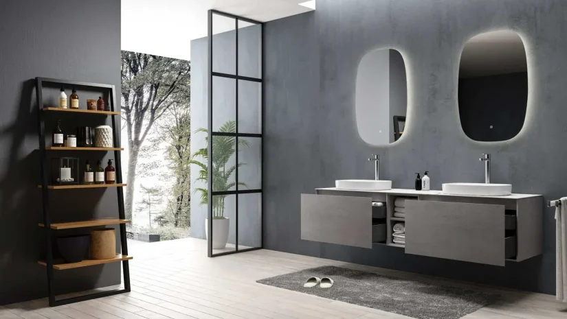 Salle de bain moderne avec étagère, écran de douche et vanité double surmontée de vasques et de miroirs de forme arrondie.