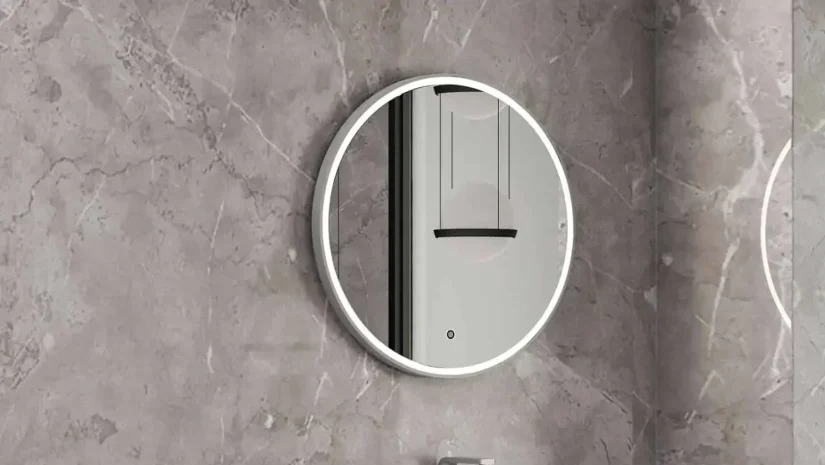 Un miroir rond à éclairage à DEL surmonte le meuble-lavabo gris donnant un aspect très tendance à la salle de bain