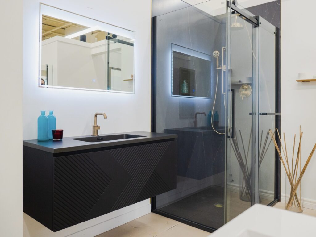 Vanité noire et douche noire avec robinetterie dorée dans une petite salle de bain moderne