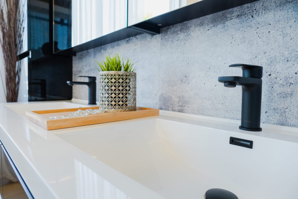 Vanité avec lavabo double pour la salle de bain et robinetterie noire, en vente chez Plomberie Aquadiva, à Laval.