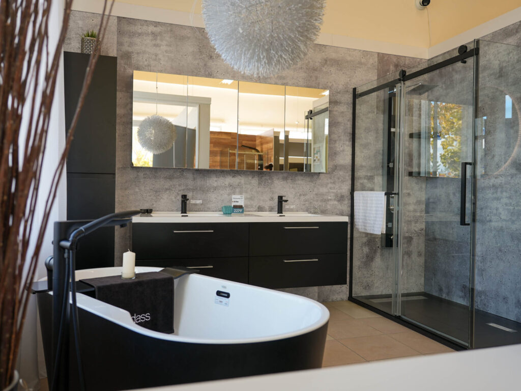 Décor de salle de bain avec robinets, baignoire, vanité et douche exposé en salle de montre chez Plomberie Aquadiva, à Laval.