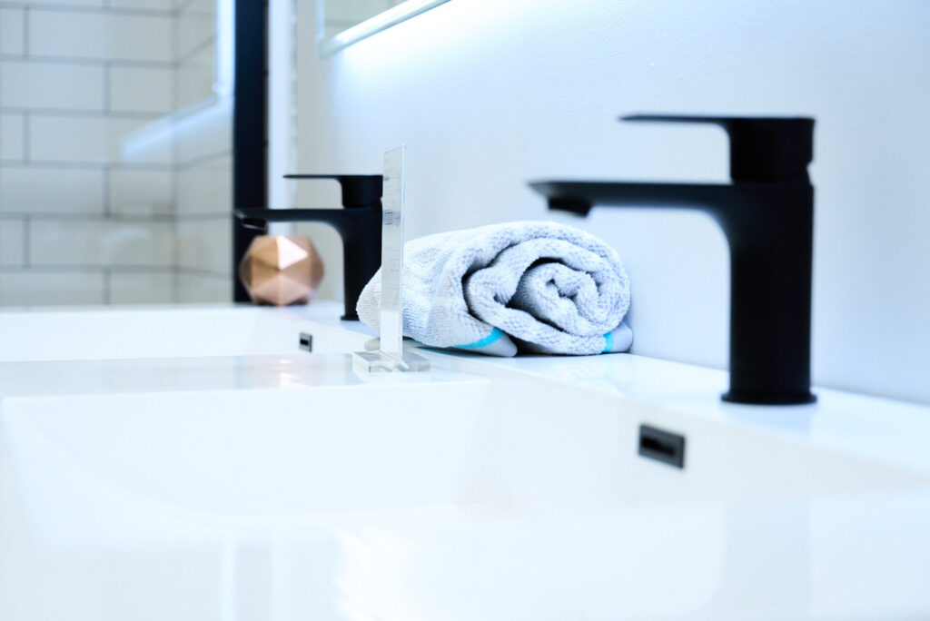Zoom sur des robinets noirs pour le lavabo de la salle de bain, en vente chez Plomberie Aquadiva, à Laval. 