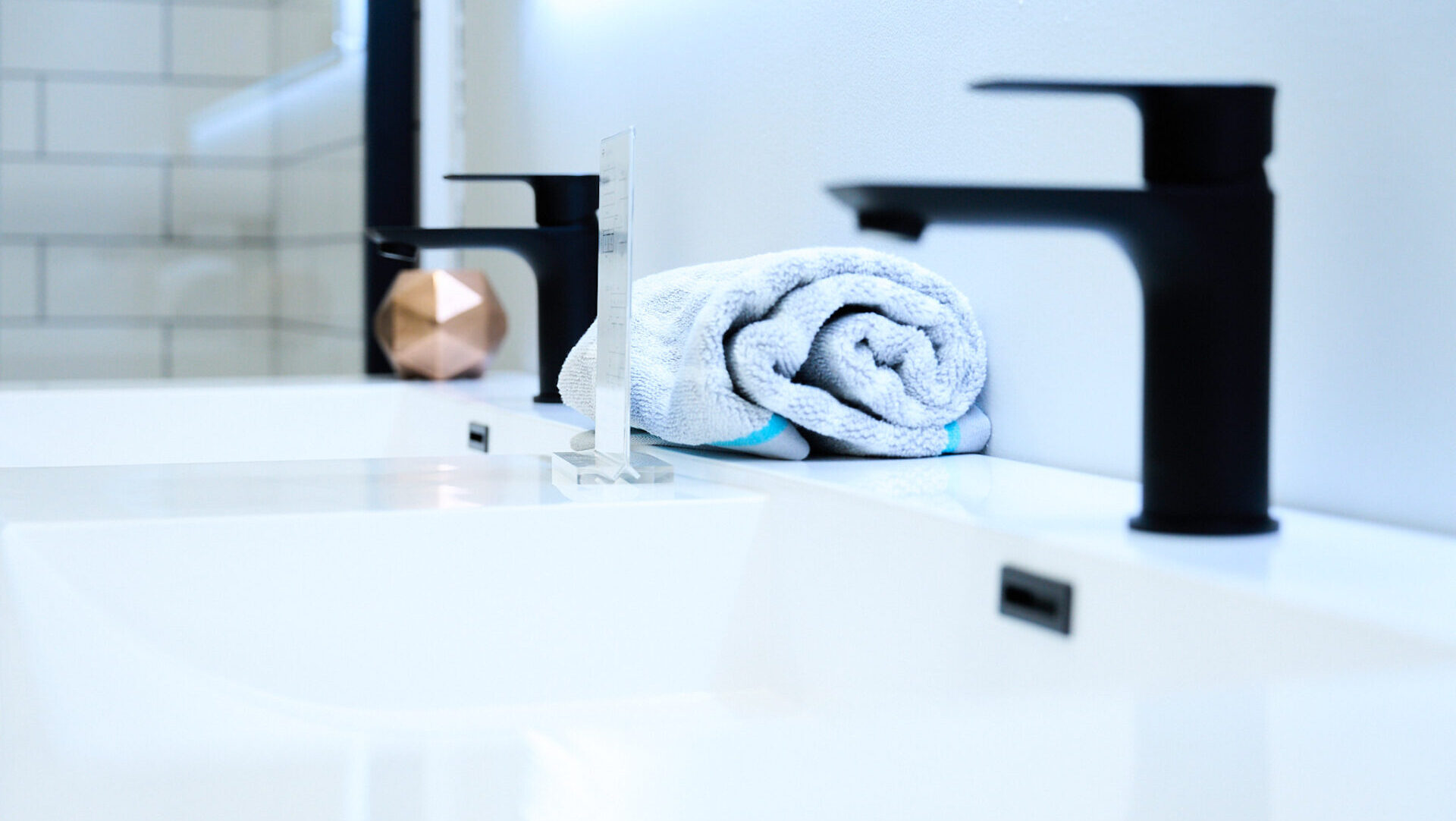 Zoom sur des robinets noirs pour le lavabo de la salle de bain, en vente chez Plomberie Aquadiva, à Laval. 
