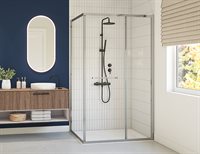 Portes de douche avec contour noir, apposées dans une douche en coin avec carrelage blanc